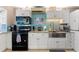 Modern kitchen with white cabinets, granite counters, and teal backsplash at 535 Narrow Pond Rd, Polk City, FL 33868