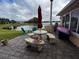 Patio with lake view, seating, grill, and umbrella at 535 Narrow Pond Rd, Polk City, FL 33868