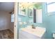 Bathroom vanity with light blue walls, white cabinetry, and a large mirror at 540 Kelsey St, Lakeland, FL 33803
