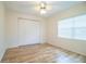 Empty bedroom with wood-look laminate flooring, closet, and window with blinds at 540 Kelsey St, Lakeland, FL 33803