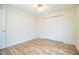 Empty bedroom featuring wood-look laminate flooring, closet, and white walls at 540 Kelsey St, Lakeland, FL 33803