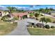 Aerial view of a single-story home with red doors, paved driveway, and landscaped yard at 561 Meandering Way, Polk City, FL 33868