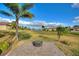 Paved patio with fire pit overlooking a tranquil pond and green space at 561 Meandering Way, Polk City, FL 33868