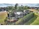 Aerial view of the backyard with a covered patio, lush landscaping, and privacy hedges at 561 Meandering Way, Polk City, FL 33868