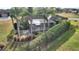 Aerial view of a backyard oasis with a screened patio, palm trees, and manicured landscaping at 561 Meandering Way, Polk City, FL 33868