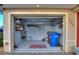 Organized garage interior with storage shelves, tools, and a blue recycling bin at 561 Meandering Way, Polk City, FL 33868