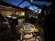 Outdoor dining area on a covered patio with comfortable seating and ambient lighting at 561 Meandering Way, Polk City, FL 33868