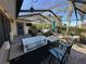 Screened-in patio featuring built-in grill, bar seating, and outdoor furniture at 561 Meandering Way, Polk City, FL 33868