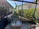 Screened patio with landscaping, wicker furniture, and a small table at 561 Meandering Way, Polk City, FL 33868