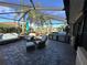 Covered patio with grill, seating area, and view of the golf course at 561 Meandering Way, Polk City, FL 33868