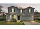 Front exterior view of two-story gray home with black front door and attached garage at 585 Scott Lake Creek Ln, Lakeland, FL 33813