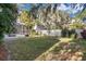Private fenced backyard with lush green lawn, mature trees, and screened pool at 6818 Hayter Drive, Lakeland, FL 33813