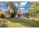 Large backyard with a screened-in pool, grassy area, and mature trees at 6818 Hayter Drive, Lakeland, FL 33813