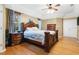 Main bedroom with wooden bed frame, matching nightstands and dresser, and hardwood floors at 6818 Hayter Drive, Lakeland, FL 33813