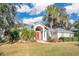 Beautiful home exterior with red front door and lush landscaping at 6818 Hayter Drive, Lakeland, FL 33813