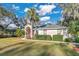 Attractive curb appeal with a red door, manicured lawn, and mature trees at 6818 Hayter Drive, Lakeland, FL 33813