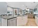 Kitchen island with white cabinets, stainless steel dishwasher, and view of the living area at 6818 Hayter Drive, Lakeland, FL 33813