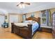 Spacious main bedroom with hardwood floors, large bed, and windows with curtains at 6818 Hayter Drive, Lakeland, FL 33813