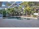 Screened-in pool with a hot tub, surrounded by a concrete patio at 6818 Hayter Drive, Lakeland, FL 33813