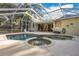 Spacious screened-in pool and hot tub with a patio area at 6818 Hayter Drive, Lakeland, FL 33813