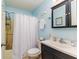 Clean bathroom with light blue walls, a dark vanity, and a shower/tub combo at 129 Rebecca Ne Dr, Winter Haven, FL 33881