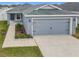 Newly constructed home with gray exterior, two-car garage, and landscaping at 1354 Mezzavalle Way, Auburndale, FL 33823