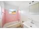 Bathroom with pink tiled walls and a bathtub at 1568 S Lake Shipp Dr, Winter Haven, FL 33880