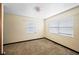 Bright bedroom featuring two windows with blinds and carpeted floors at 1568 S Lake Shipp Dr, Winter Haven, FL 33880