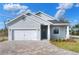 New construction home with gray exterior, white garage door, and paver driveway at 2116 Sarah Way, Mulberry, FL 33860