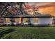 White house with a dark roof, well-manicured lawn, and sunset view at 425 E Belmar St, Lakeland, FL 33803