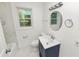 Updated bathroom with a white vanity, marble-tiled floors, and bathtub at 4925 Magnolia Ave, Mulberry, FL 33860