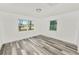 Bedroom with wood-look floors and two windows with views of nature at 4925 Magnolia Ave, Mulberry, FL 33860