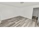 Bright bedroom with wood-look floors and an open door to hallway at 4925 Magnolia Ave, Mulberry, FL 33860