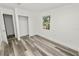 Spacious bedroom with wood-look floors, a closet, and a window at 4925 Magnolia Ave, Mulberry, FL 33860