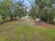 Large backyard with mature trees and a small trailer at 210 Wilder Rd, Lakeland, FL 33809