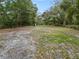Open backyard with mature trees and a partially fenced area at 210 Wilder Rd, Lakeland, FL 33809