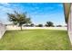 Large backyard with grassy area and tree, white fence at 332 Lake Mariana Way, Auburndale, FL 33823