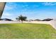 Spacious grassy backyard with tree and white fence at 332 Lake Mariana Way, Auburndale, FL 33823
