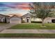 Single-story house with a two-car garage, landscaped lawn, and walkway at 332 Lake Mariana Way, Auburndale, FL 33823