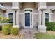Front entrance with a navy blue door and two chairs at 332 Lake Mariana Way, Auburndale, FL 33823