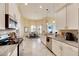 Modern kitchen with white cabinets, granite counters, and stainless steel appliances at 332 Lake Mariana Way, Auburndale, FL 33823