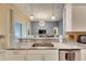 Kitchen features granite countertops and a double sink overlooking the living room at 332 Lake Mariana Way, Auburndale, FL 33823