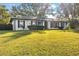White brick ranch house with gray shutters, landscaping, and a large yard at 4409 Hallam Hill Ln, Lakeland, FL 33813