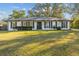 White brick ranch house with gray shutters, landscaping, and a large yard at 4409 Hallam Hill Ln, Lakeland, FL 33813