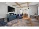 Living room with sectional sofa, wood-look flooring, and exposed beams at 4409 Hallam Hill Ln, Lakeland, FL 33813