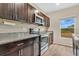 Modern kitchen features dark wood cabinets, granite countertops, and stainless steel appliances at 5460 Siltstone St, Lakeland, FL 33811