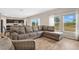 Living room with L-shaped sofa, armchair, and large windows at 5460 Siltstone St, Lakeland, FL 33811