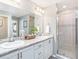 Double vanity bathroom with walk-in shower and grey tile at 734 Sw 77Th Cir, Ocala, FL 34474