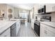 Spacious kitchen featuring white cabinets, granite countertops, and stainless steel appliances at 734 Sw 77Th Cir, Ocala, FL 34474