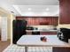 Modern kitchen with dark wood cabinets, black appliances, and a spacious countertop at 4241 Oak Loop # 36, Mulberry, FL 33860